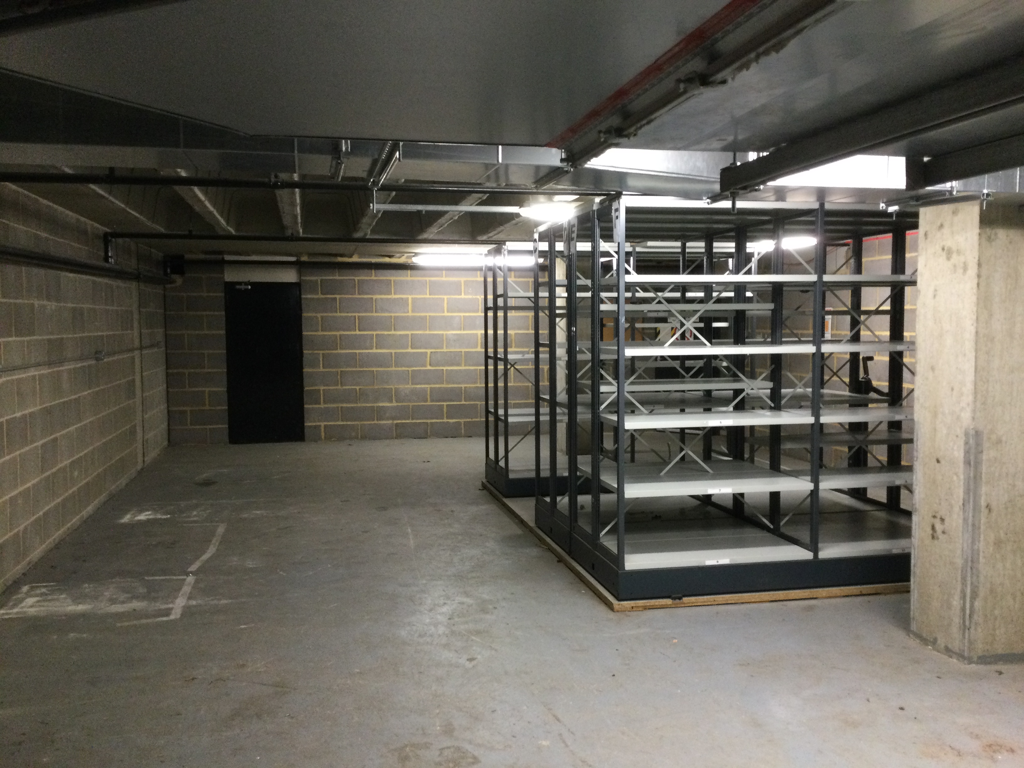 An empty basement storage area with empty shelves on the right.