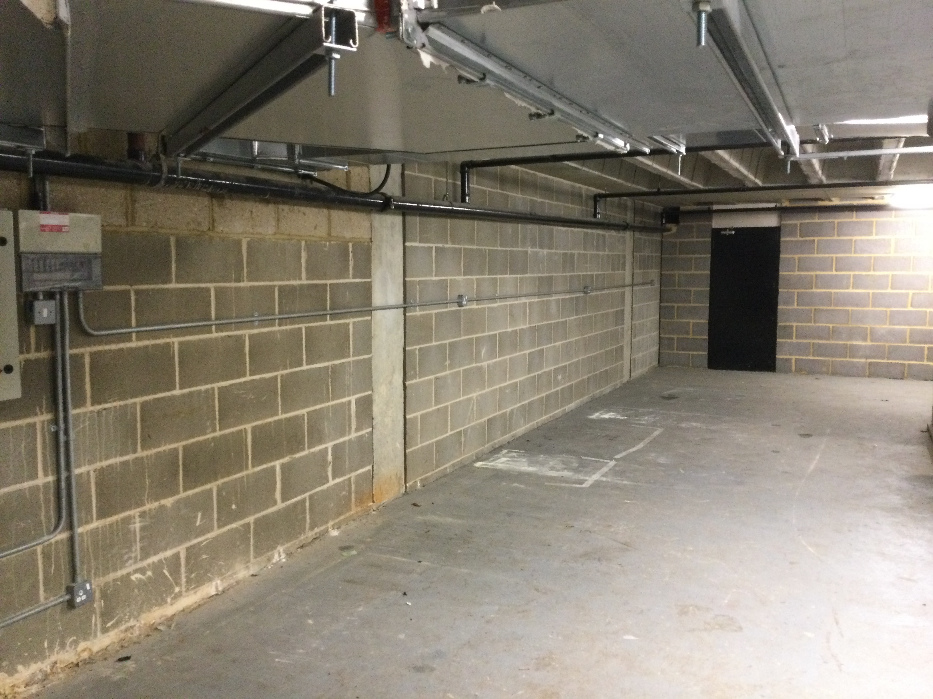 An empty basement storage area with empty shelves on the right.
