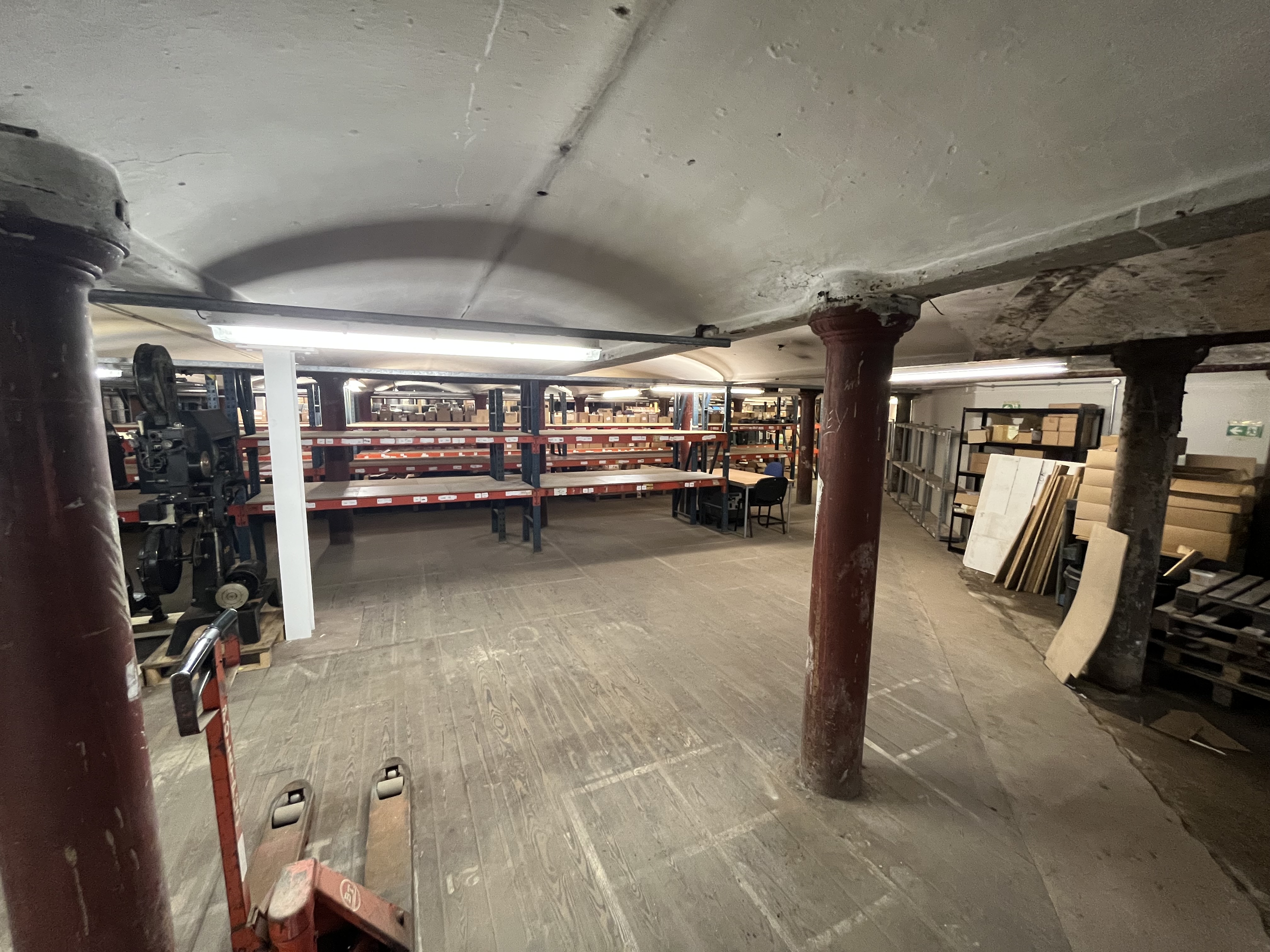A basement storage area, with empty shelves and space on the floor.