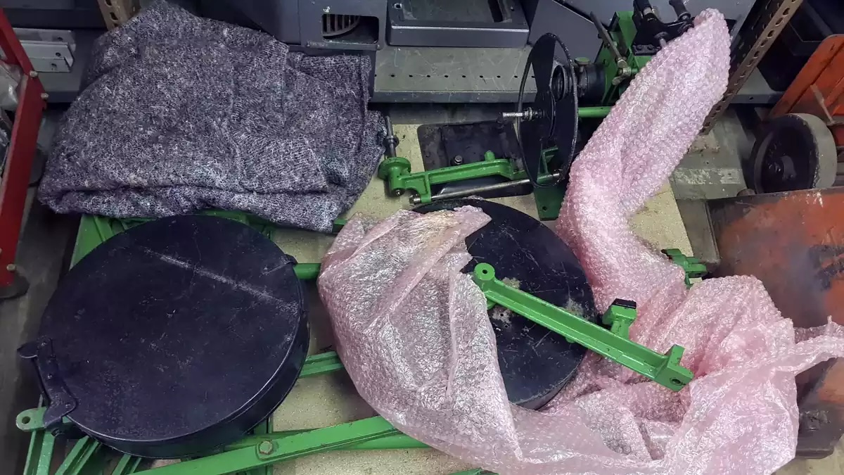 Projector parts on a pallet. There are black round boxes, and a green metal frame.