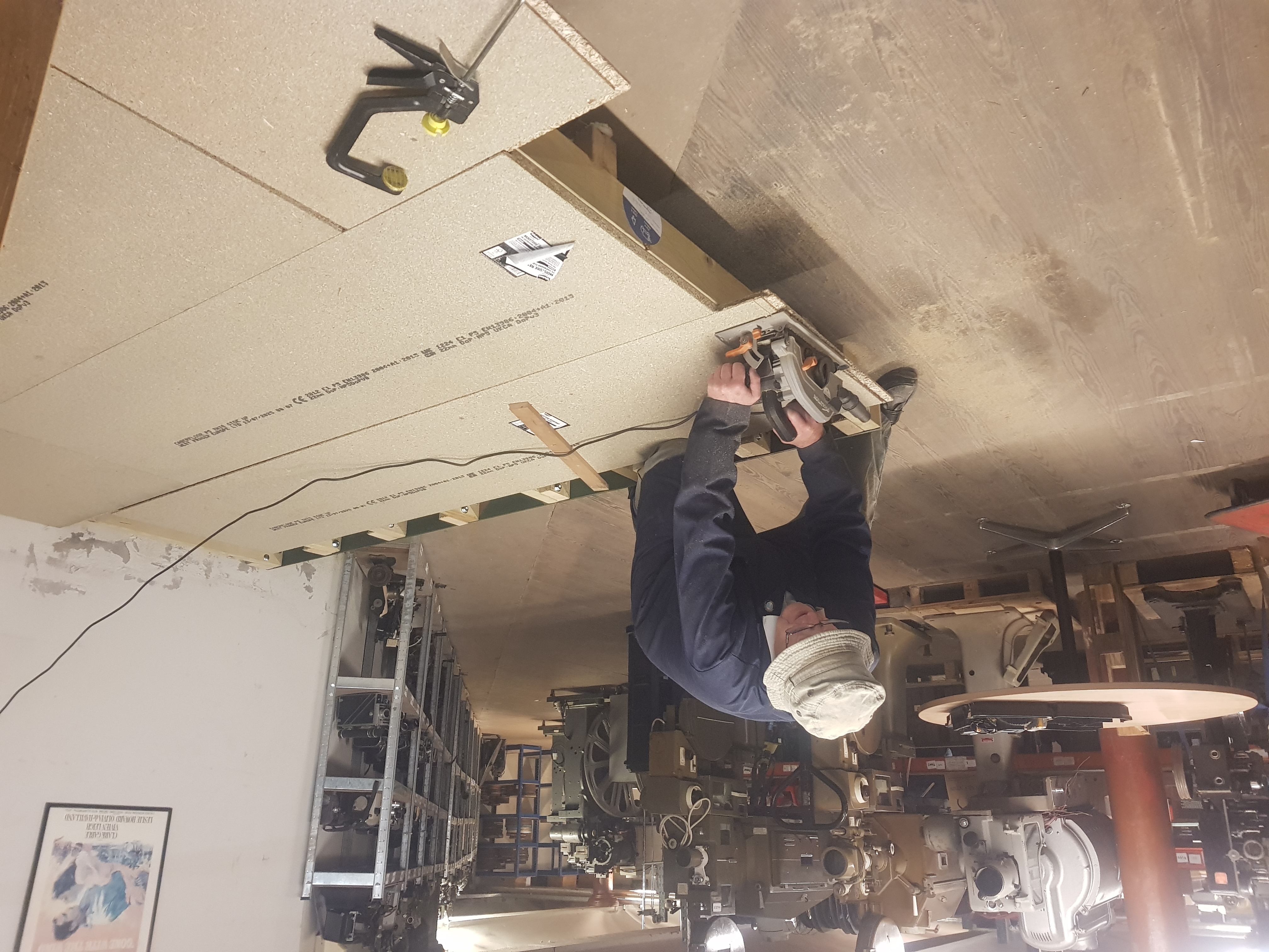 A man with a circular saw, cutting floorboards to size