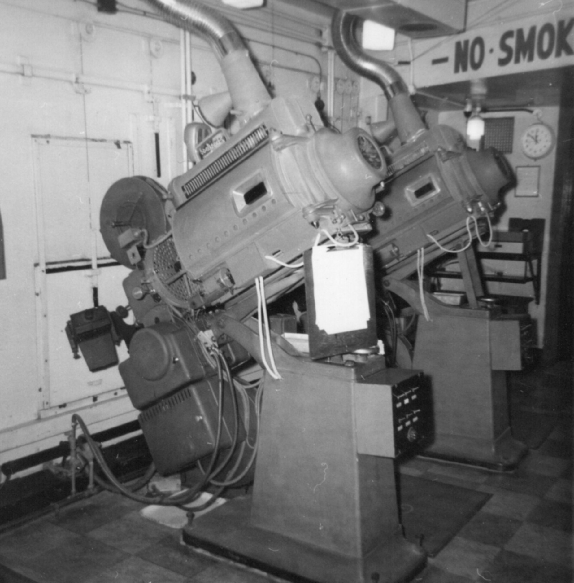 The back side of two projectors in a projection room